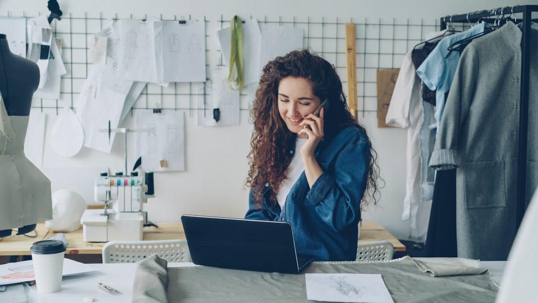 Small business owner working on a laptop in a tailoring studio